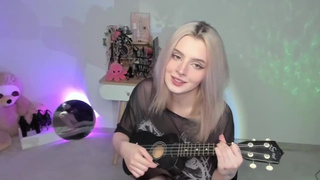 Alluring blonde chick playing on ukulele and singing in dirty outfit